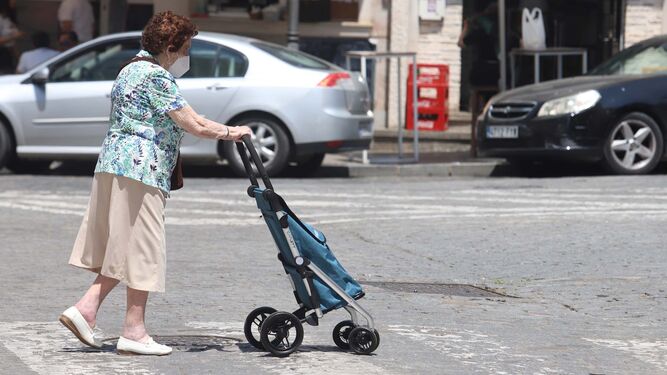 Una mujer pasea por Huelva con su mascarilla.