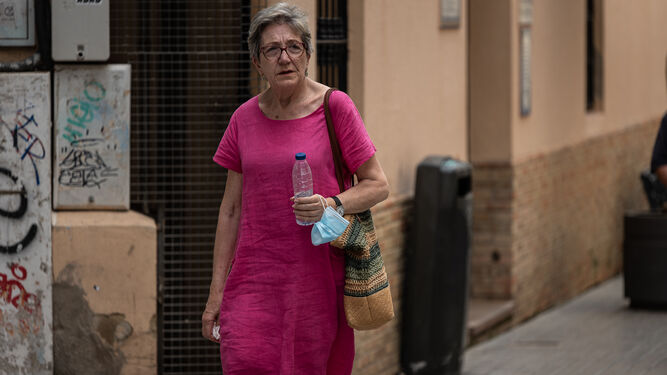 Una mujer con una botella de agua para combatir el calor.