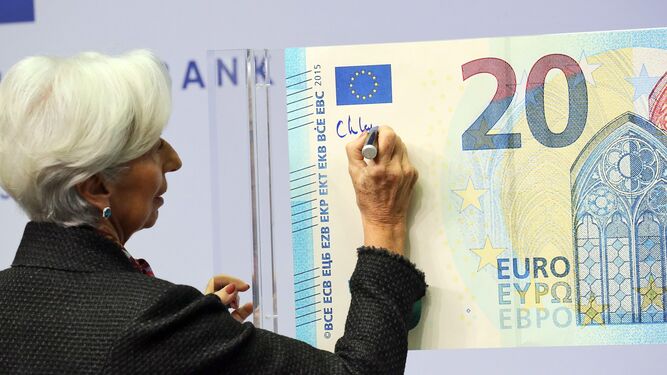 Christine Lagarde, presidenta del BCE, firma un billete de 20 euros