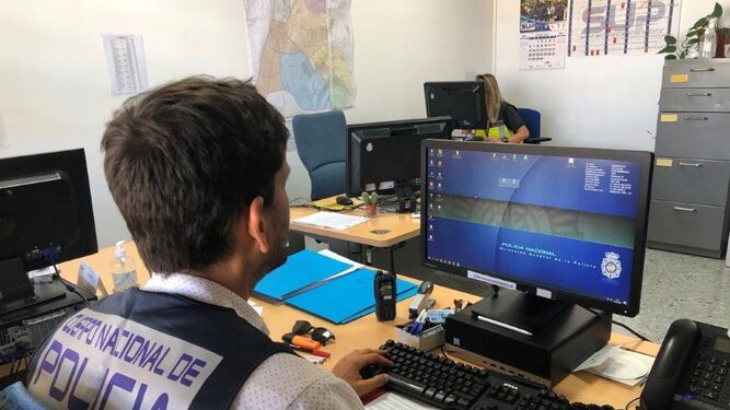 Un policía nacional trabaja en un ordenador.