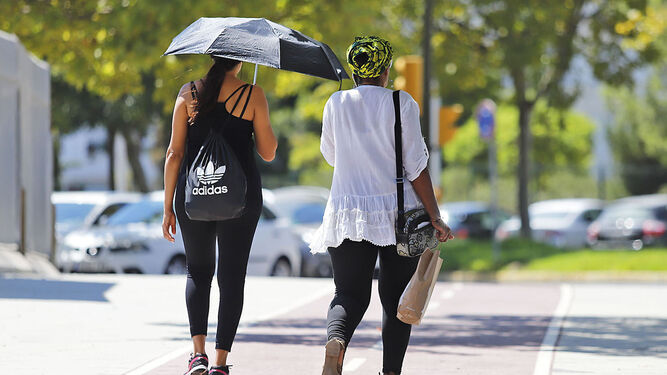 Una joven se protege del sol con un paraguas.