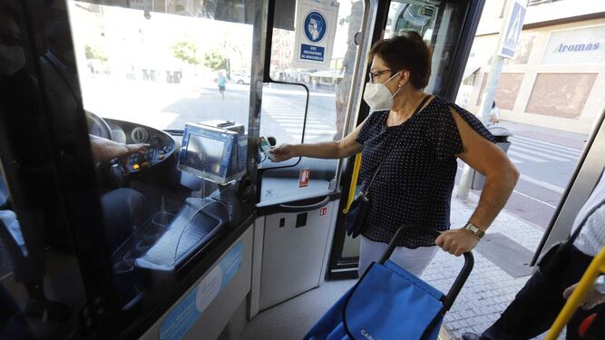 Una usuaria paga con su tarjeta de bonobús al montarse en el autobús.