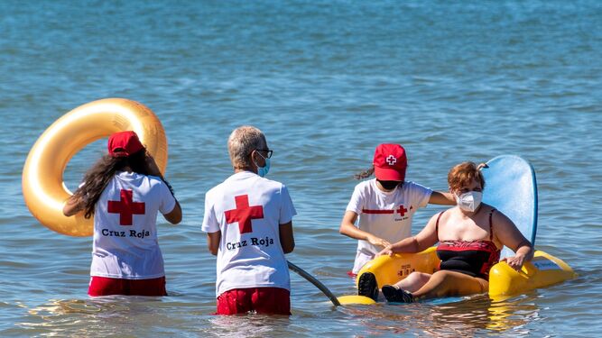 Voluntarios de Cruz Roja con una usuaria del programa.