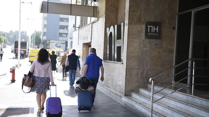 Viajeros abandonan uno de los hoteles de la capital onubense.