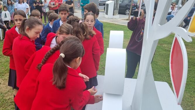 Alumnos de Aljaraque colocan sus mensajes en la escultura.