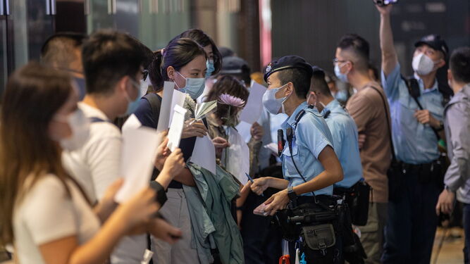 La Policía identifica a los participantes en la vigilia por las víctimas del incendio de Urumqi en Hong Kong.