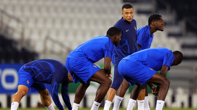 Mbappé dialoga con varios compañeros en el estiramiento previo al entrenamiento de Francia.