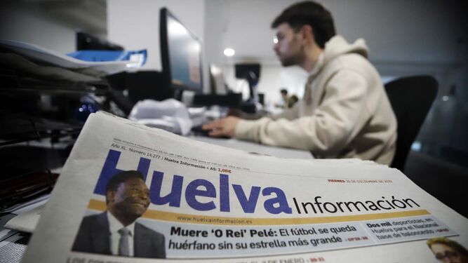 Un ejemplar de la edición en papel en primer término en la redacción de 'Huelva Información'.
