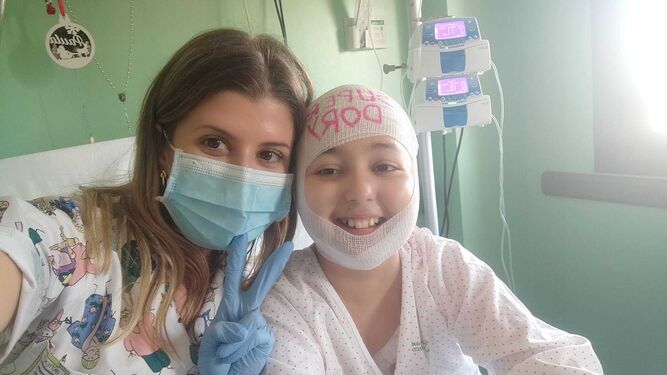 La pequeña Paula junto a su enfermera, Ángela, en el Hospital Juan Ramón Jiménez