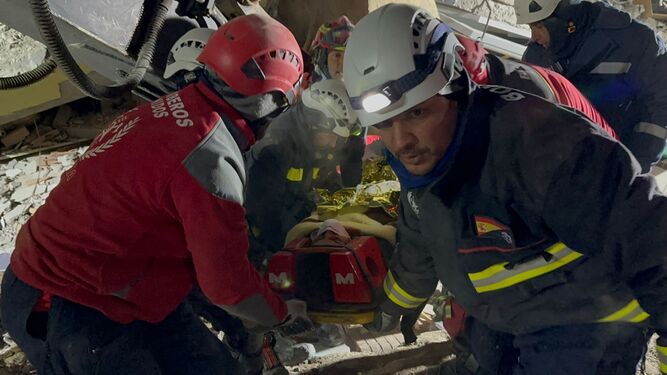 Bomberos  durante el rescate de una joven atrapada en  los escombros tras el derrumbre de viviendas en  Turquía  debido al terremoto.