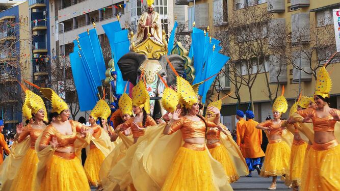 Una de las carrozas de la cabalgata del Carnaval de Isla Cristina, precedida por un grupo de baile