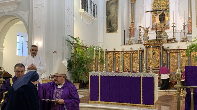 El obispo de Huelva impone la ceniza a una monja.