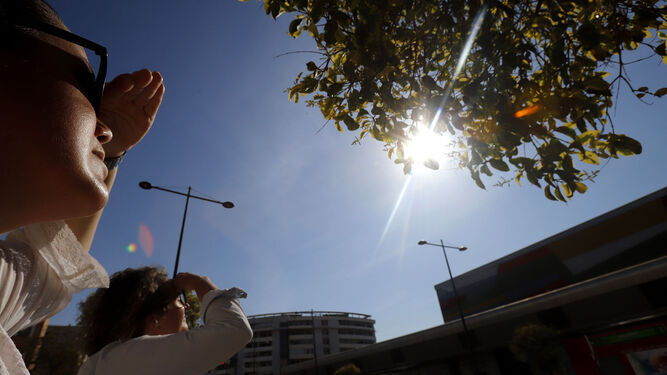 Dos mujeres disfrutan del sol de marzo en las calles de Huelva capital