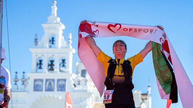 Participante cruzando la meta del Doñana Trail Marathon en El Rocío.