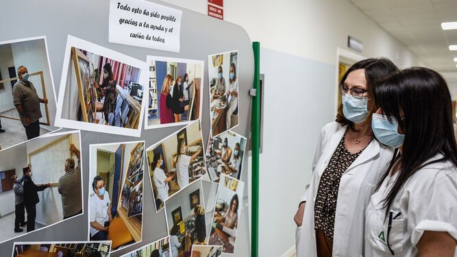 Dos profesionales del hospital Infanta Elena miran una de las exposiciones de fotografías del centro.