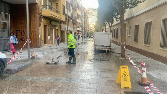 Un operario del Ayuntamiento de Huelva limpia la cera de la calle.
