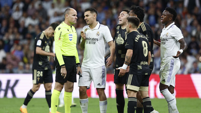 Mateu Lahoz, serio, escucha las protestas de jugadores del Real Madrid y del Celta.