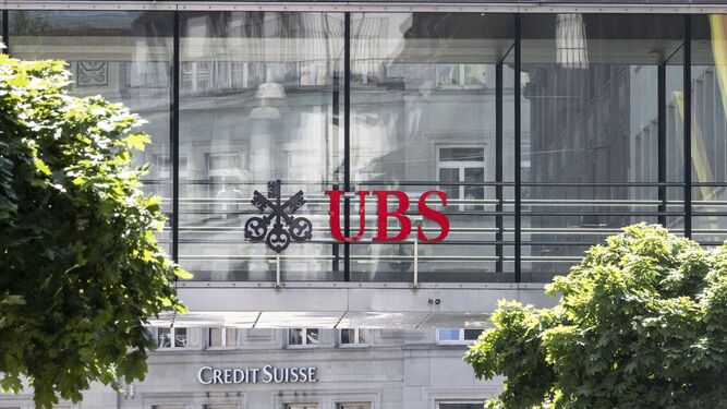 Logos de UBS y Credit Suisse en la fachada de dos edificios.