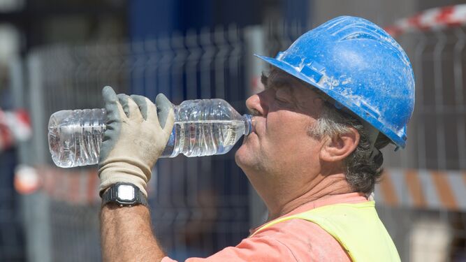Un obrero de la construcción bebe agua.