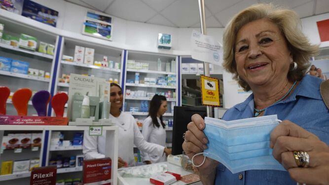 Una señora sonríe al entrar en la farmacia porque ya no tiene que llevar puesta la mascarilla