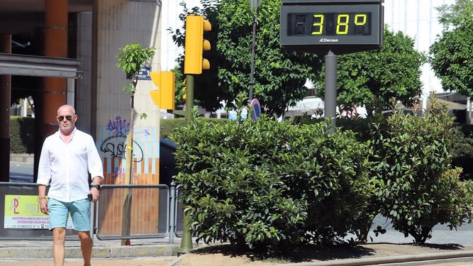 Un señor pasea por el centro de Huelva mientras que el termómetro marca 38 grados