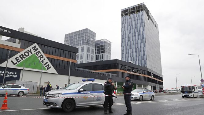 Policías rusos permanecen en guardia cerca de un edificio atacado con drones en Moscú.