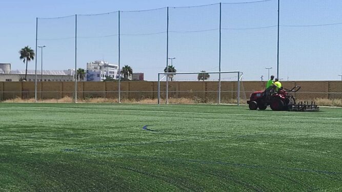 Una maquina realiza tareas de preparación de los campos de césped artificial de Huelva