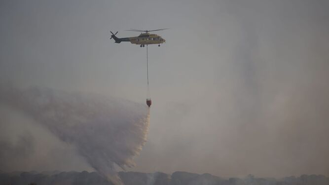 Un helicóptero tratando de apagar el incendio de Bonares.