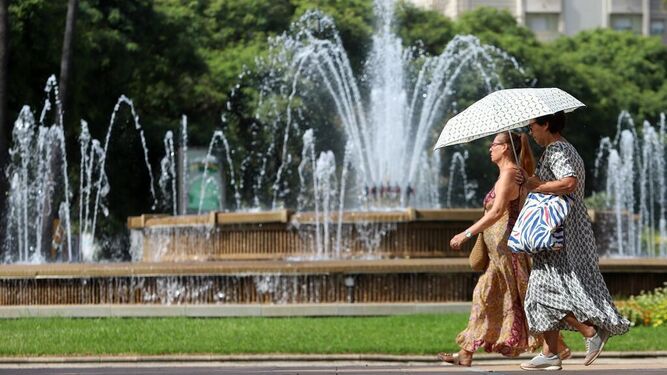 Dos mujeres se protegen del sol con un paraguas en la ciudad
