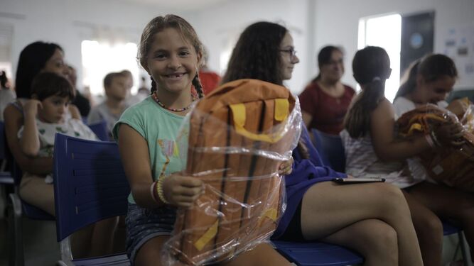 Una de las menores con el material escolar donado por la Fundación La Caixa