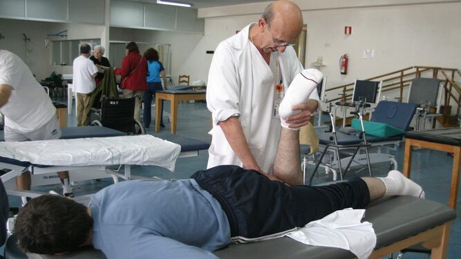 Un fisioterapeuta realiza ejercicios a un paciente