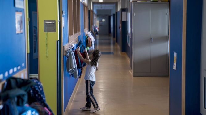 Una alumna cuelga su mochila en el pasillo de un colegio