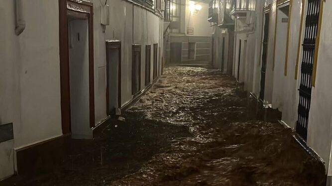 La calle Bodegueta de Constantina inundada por la tormenta de la noche.