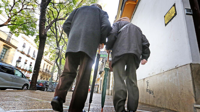 Dos mayores caminan por la calle.