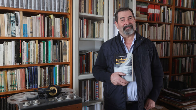 Miguel Ángel Fernández posa con su nuevo libro en la biblioteca de su casa