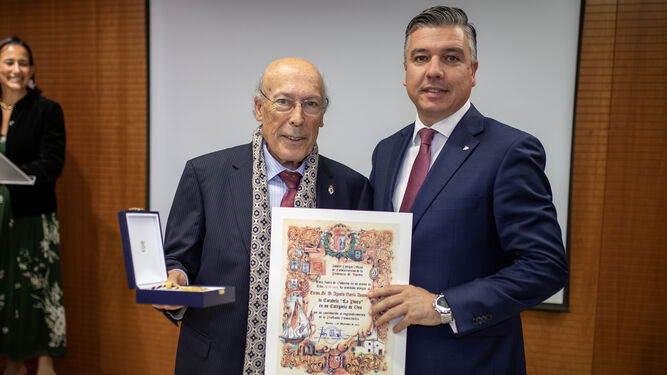 García Asuero recibe el reconocimiento de manos del presidente del Colegio de Farmacéuticos de Huelva, Jorge Juan García.