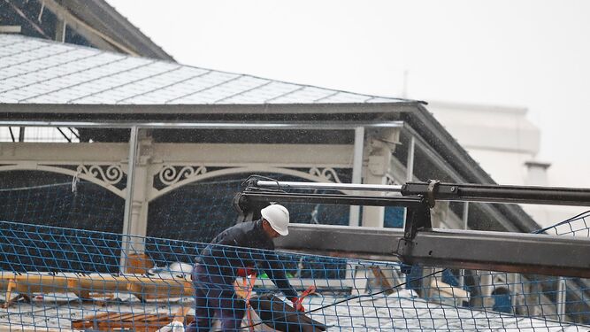 Un obrero realiza el mantenimiento de un tejado