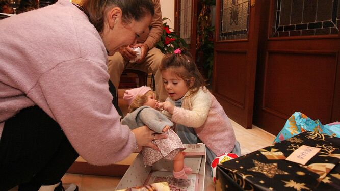 Una niña abre un regalo de Reyes en Huelva.