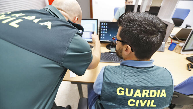 Dos agentes de la Guardia Civil trabajan en una unidad especializada en delitos informáticos.