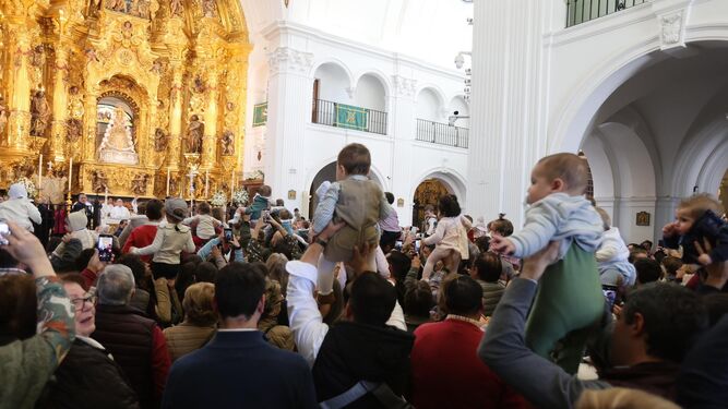Padres y madres presentan a sus hijos ante la Virgen del Rocío.