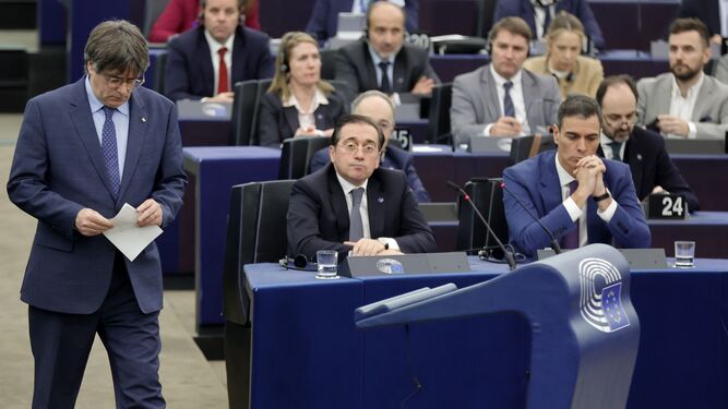 Carles Puigdemont accede a la tribuna de oradores de la Eurocámara junto al ministro José Manuel Albares y el presidente Pedro Sánchez.