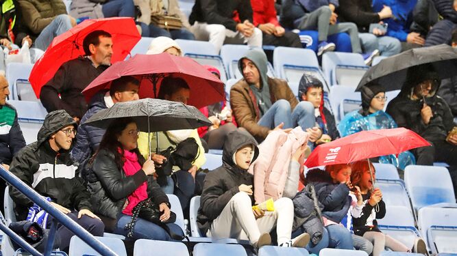 Aficionados del Recre se protegen de la lluvia en el partido con el San Fernando de la primera vuelta.