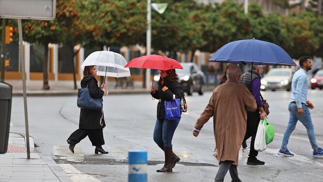 Los onubenses pasean por la capital onubense con sus paraguas en la jornada del jueves.