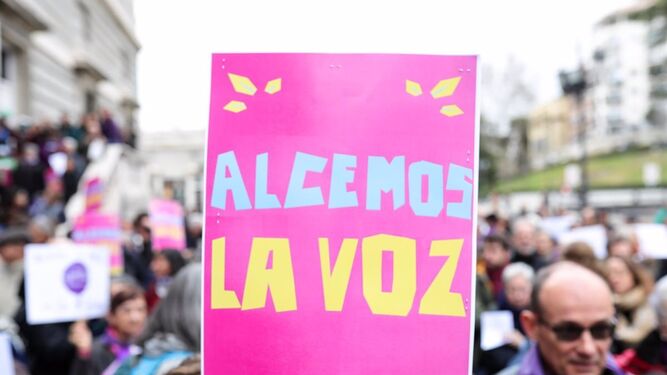 Participante en la concentración de la plataforma Revuelta de Mujeres en la Iglesia junto a la catedral de la Almudena lleva un cartel que dice 'Alcemos la voz', en Madrid en 2020