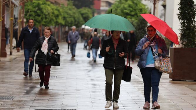 Dos mujeres se protegen de la lluvia este lunes en Huelva