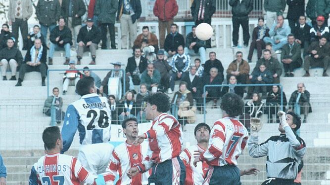 Gregorio Molina salta por un balón ante la presencia de varios jugadores del Atlético B
