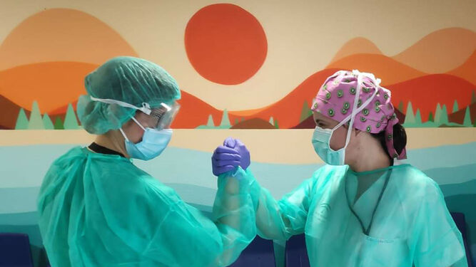 Dos enfermeras chocan sus manos en el hospital Juan Ramón Jiménez.