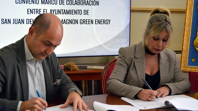 El representante de Magnon Green Energy y la alcaldesa de San Juan del Puerto firman un acuerdo para impulsar una ayuda económica.